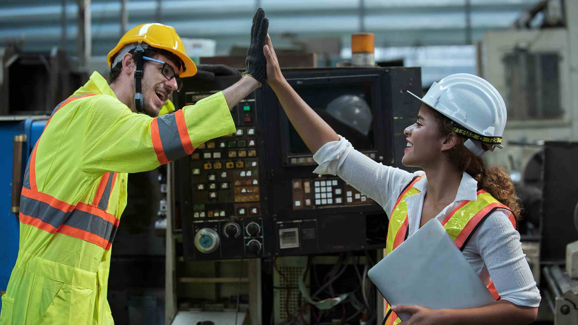 2 machine operators sharing a high five